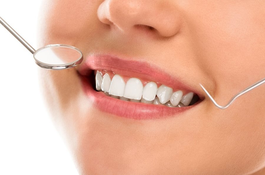 Sorriso de paciente observado com espelho dentário, cirurgia oral em Braga